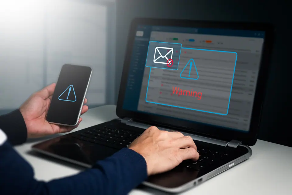 A businessman sees a caution window while working on a laptop at home