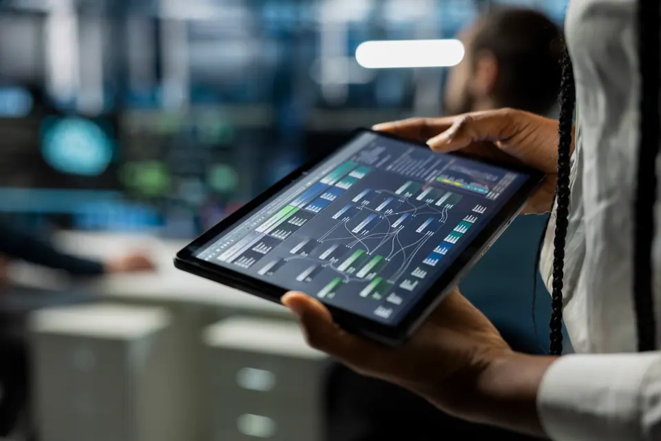 Close up of data center developer running simulations on tablet for AI forecasting, tracking performance