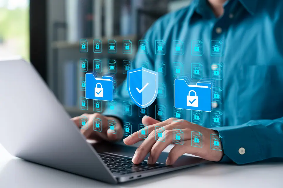 Cybersecurity concept with businessman using a laptop to protect data folders and digital files