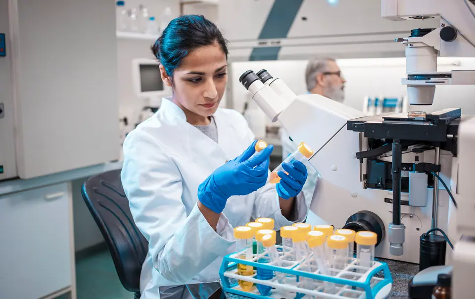 Female scientist working in the lab, using microscope