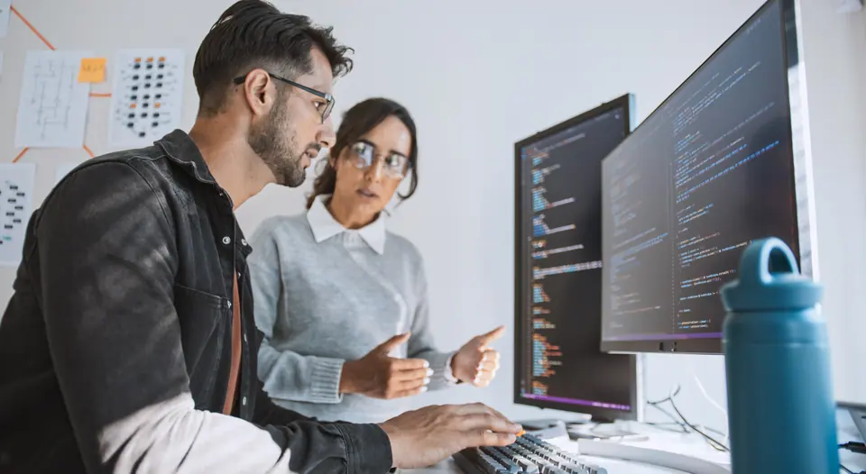 Hispanic Latin American couple, software engineer developer use computer, work on program coding together at home office