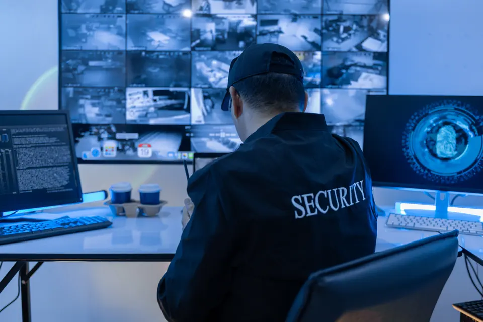 Security Man guard, Working in Control room by cctv monitor for protection, data center or building safety