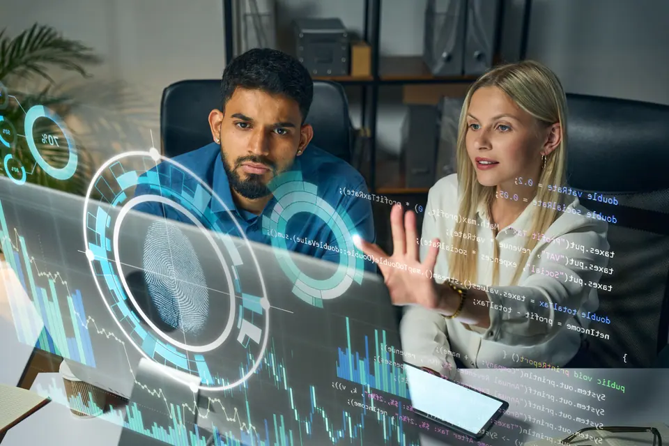 Two professionals collaborating on futuristic virtual interface, analyzing data and cybersecurity graphics, emphasizing innovation, technology, and…