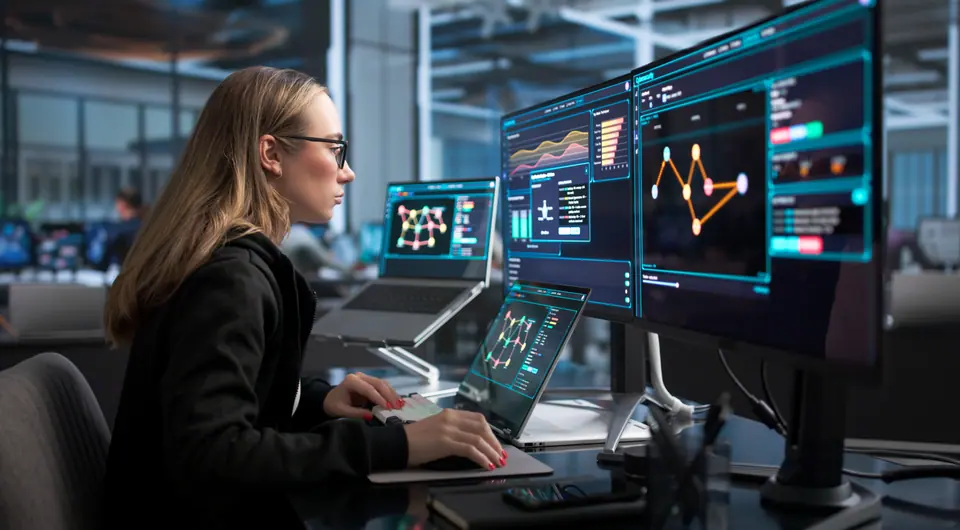 Woman works on laptop monitoring real-time network security threats