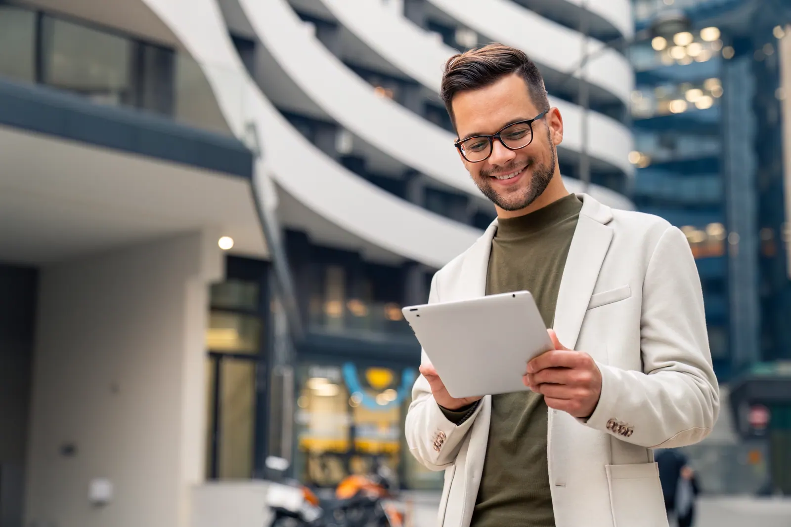 Businessperson using a tablet outside a modern building