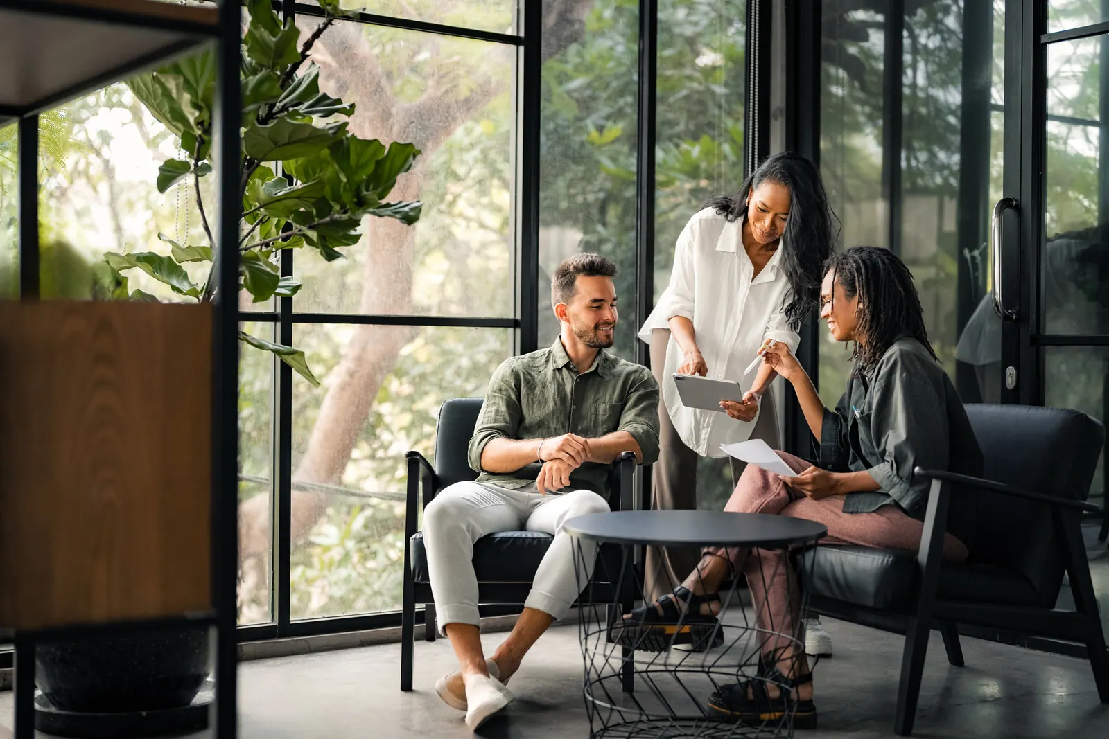 Colleagues discussing work around a table in a lounge