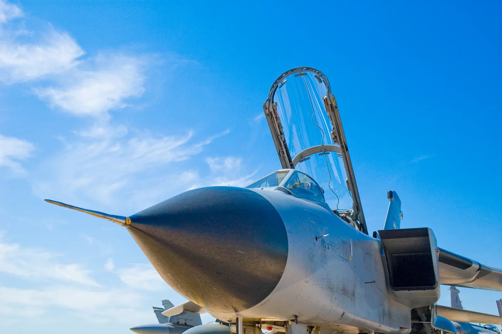 Aircraft with its cockpit canopy open beneath a blue sky